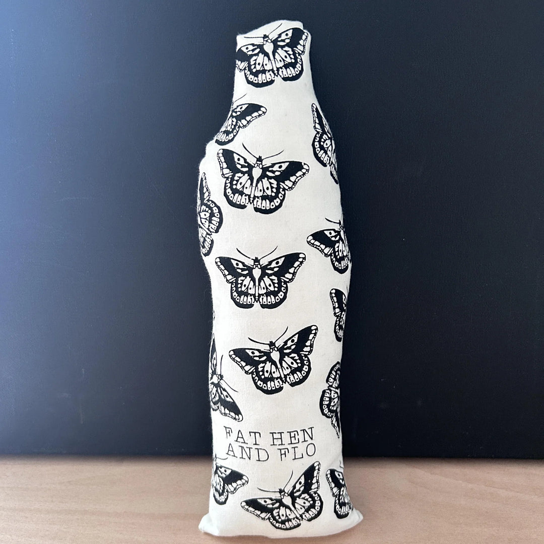 Reverse of screen printed doll cushion, white fabric with black printed butterflies and the brand name 'Fat Hen And Flo'