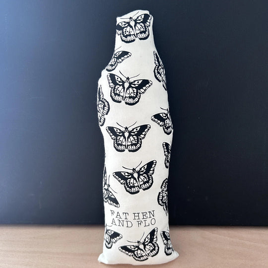 Reverse of screen printed doll cushion, white fabric with black printed butterflies and the brand name 'Fat Hen And Flo'