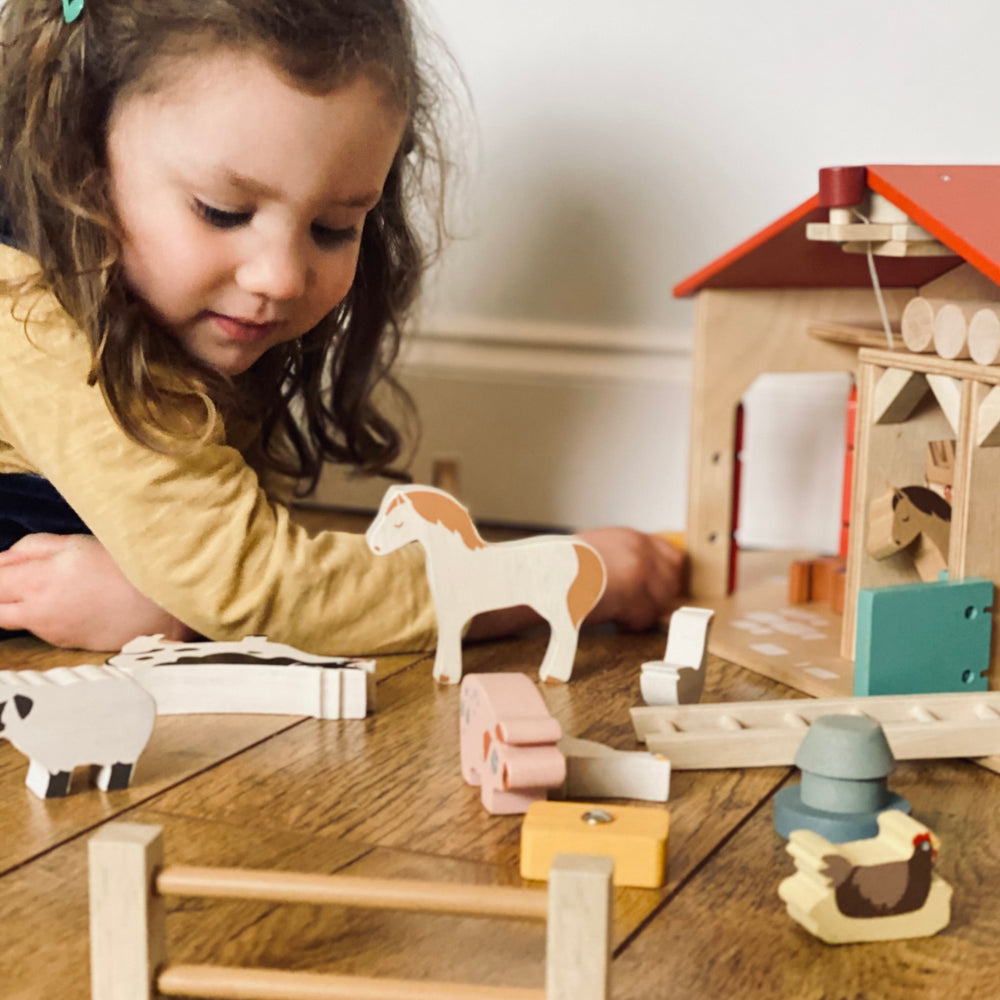 Child playing with wooden toys on a table