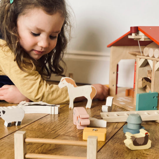 Child playing with wooden toys on a table