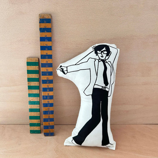 Screen printed doll cushion of Jarvis Cocker next to two wooden rulers on a wooden background