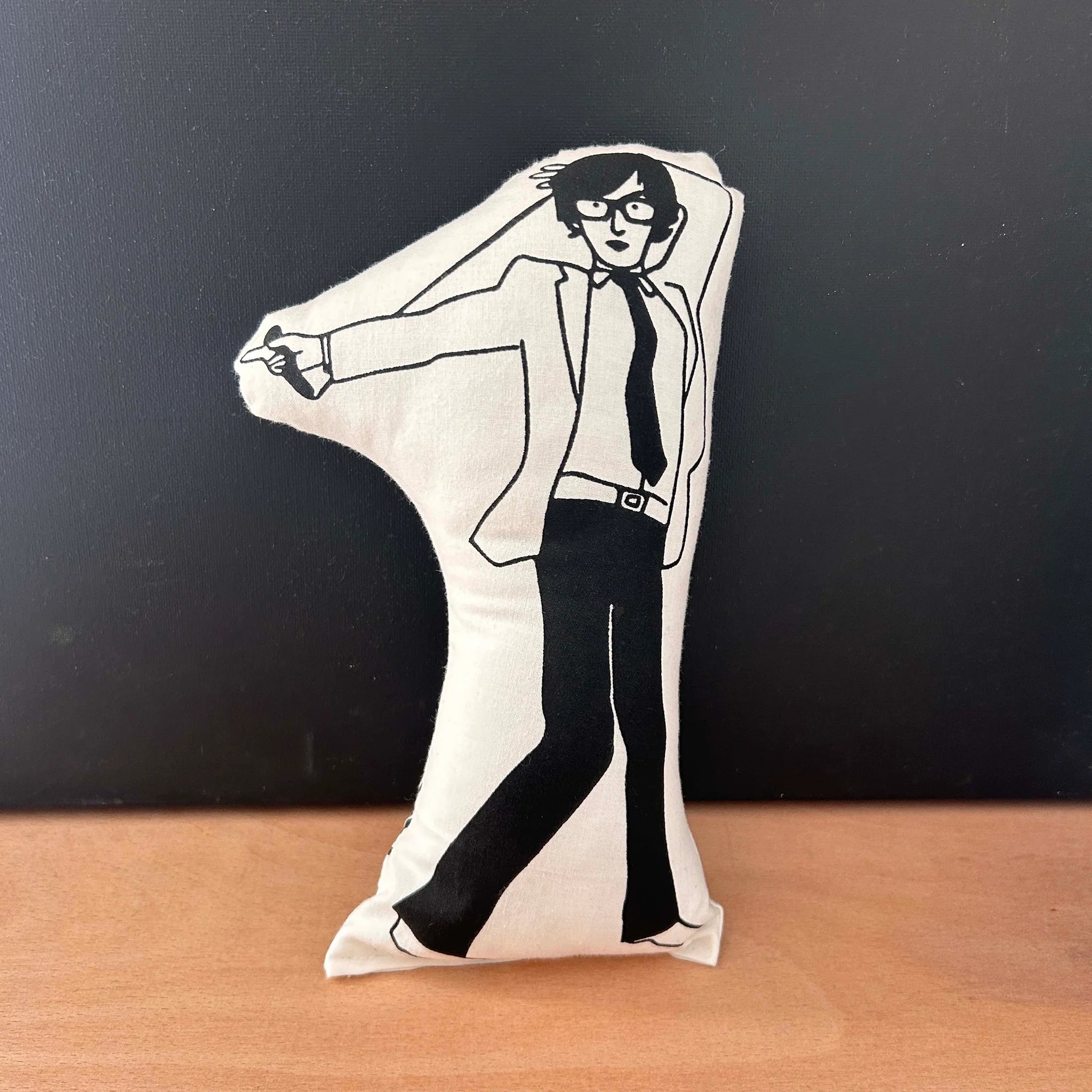 Screen printed doll cushion with white fabric and black illustration depicting musician Jarvis Cocker dancing in a suit and thick rimmed glasses