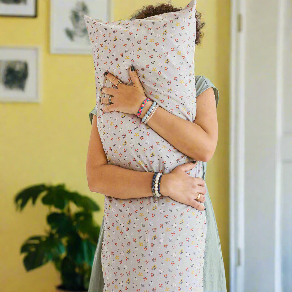 Person hugging pregnancy support pillow