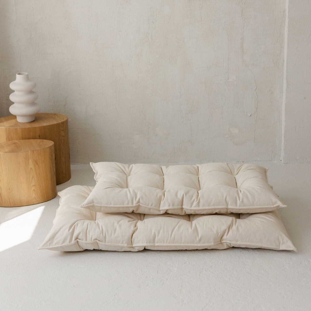 Two different sized floor cushions stacking on top of each other in a room