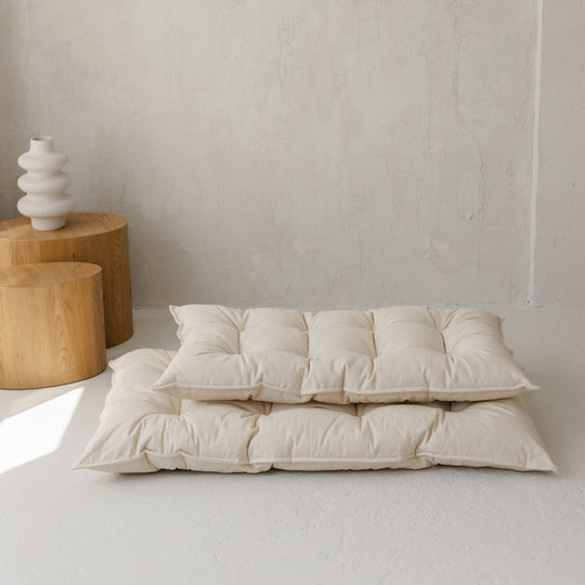 Two different sized floor cushions stacking on top of each other in a room