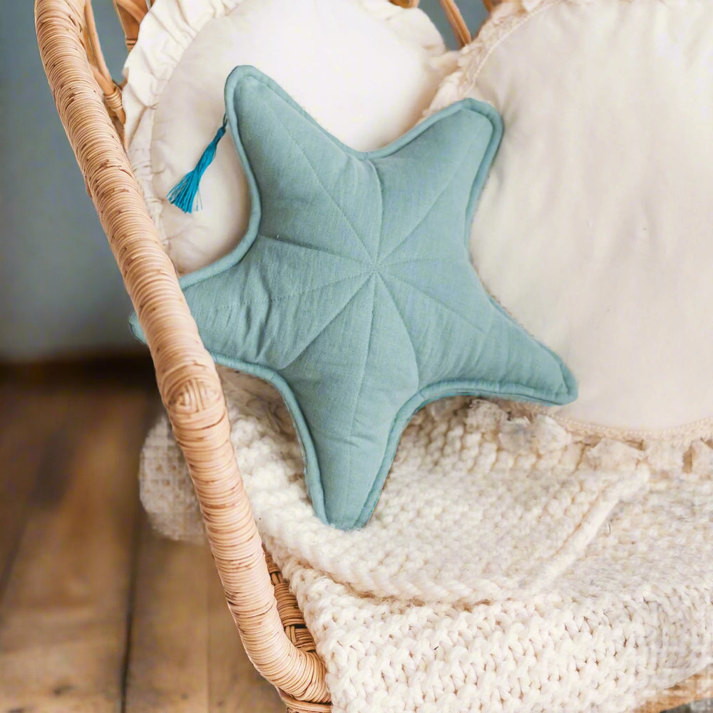 Blue star-shaped pillow on a textured surface with a woven basket