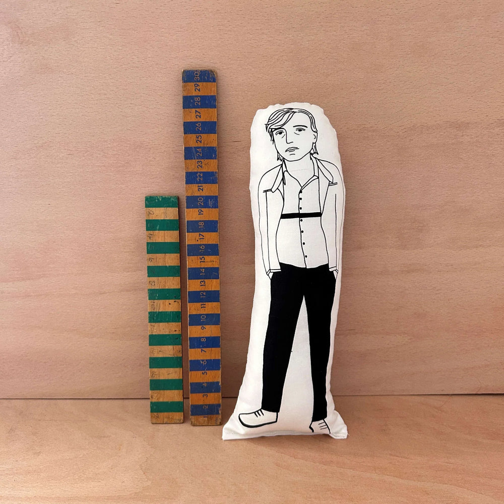 Screen printed doll cushion of Mark E Smith next to two wooden rulers on a wooden background