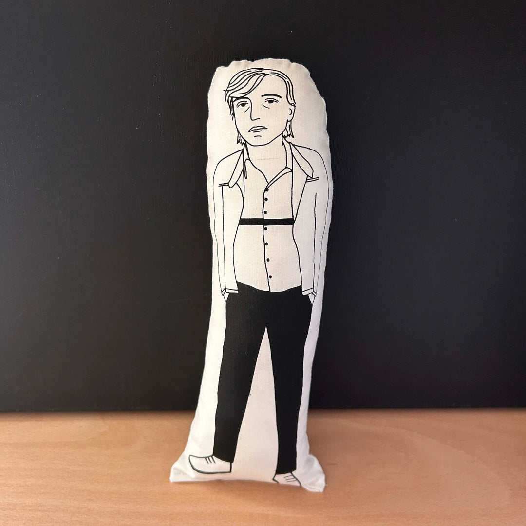 Screen printed doll cushion with white fabric and black illustration depicting The Fall frontman Mark E Smith with his hands in his pockets
