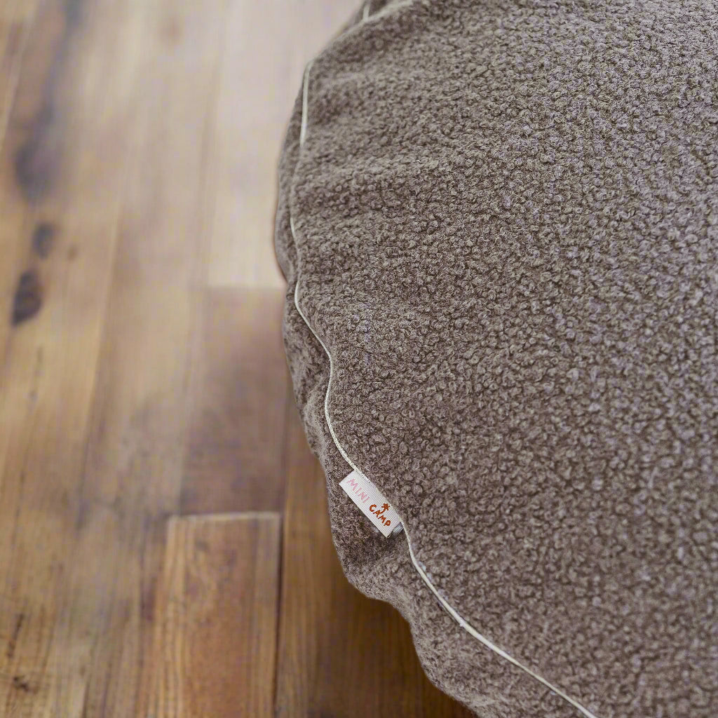 Close up of floor cushion showing the textured bobbly grey fabric