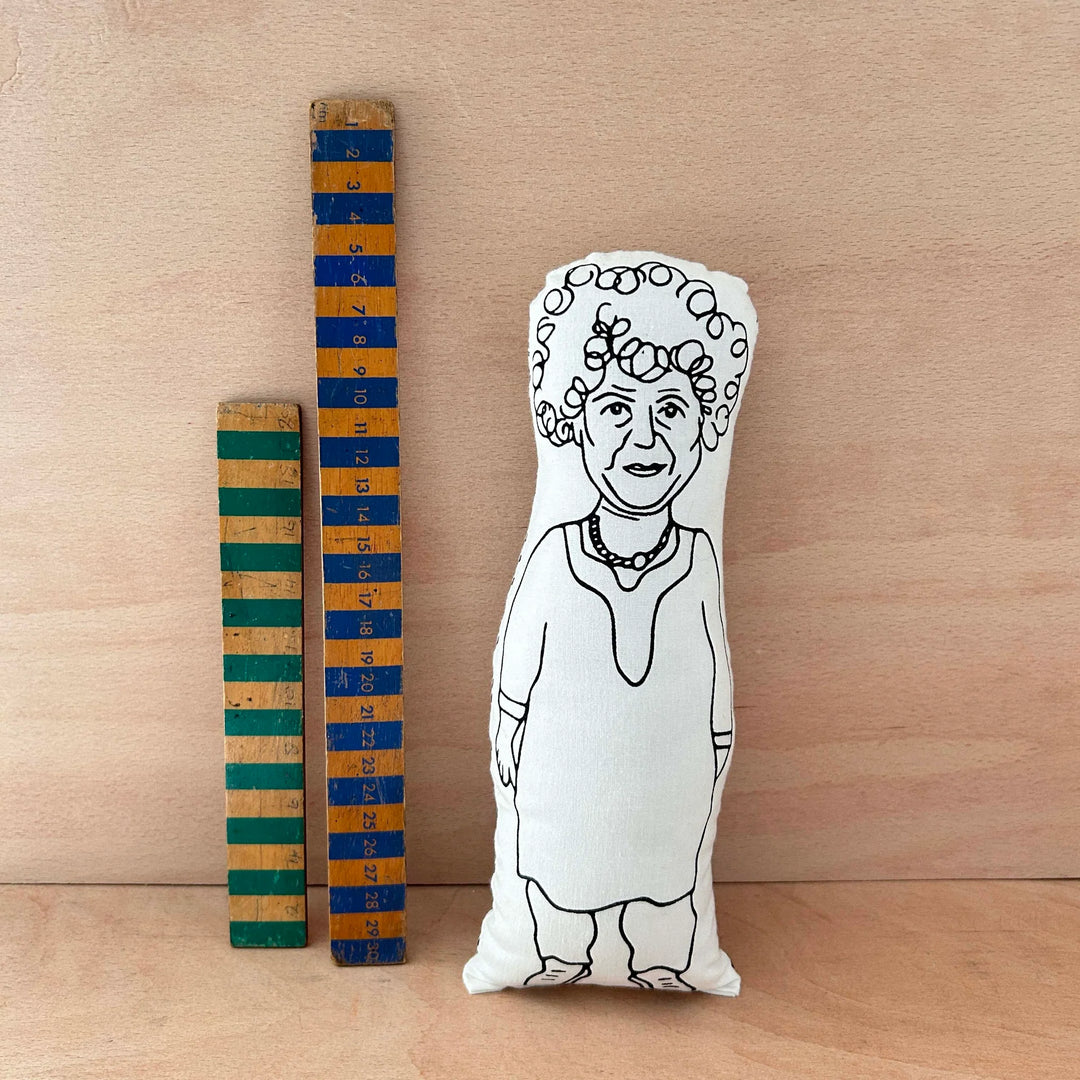 Screen printed doll cushion of actor Miriam Margolyes next to two wooden rulers