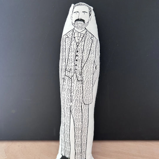 Screen printed doll cushion with white fabric and black illustration depicting Patrick Grant from the Great British Sewing Bee wearing a three-piece tweed suit and bow tie