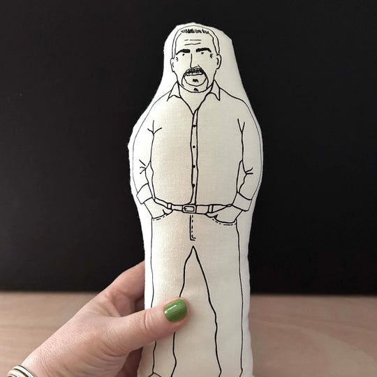 Hand holding screen printed doll cushion of Paul Hollywood