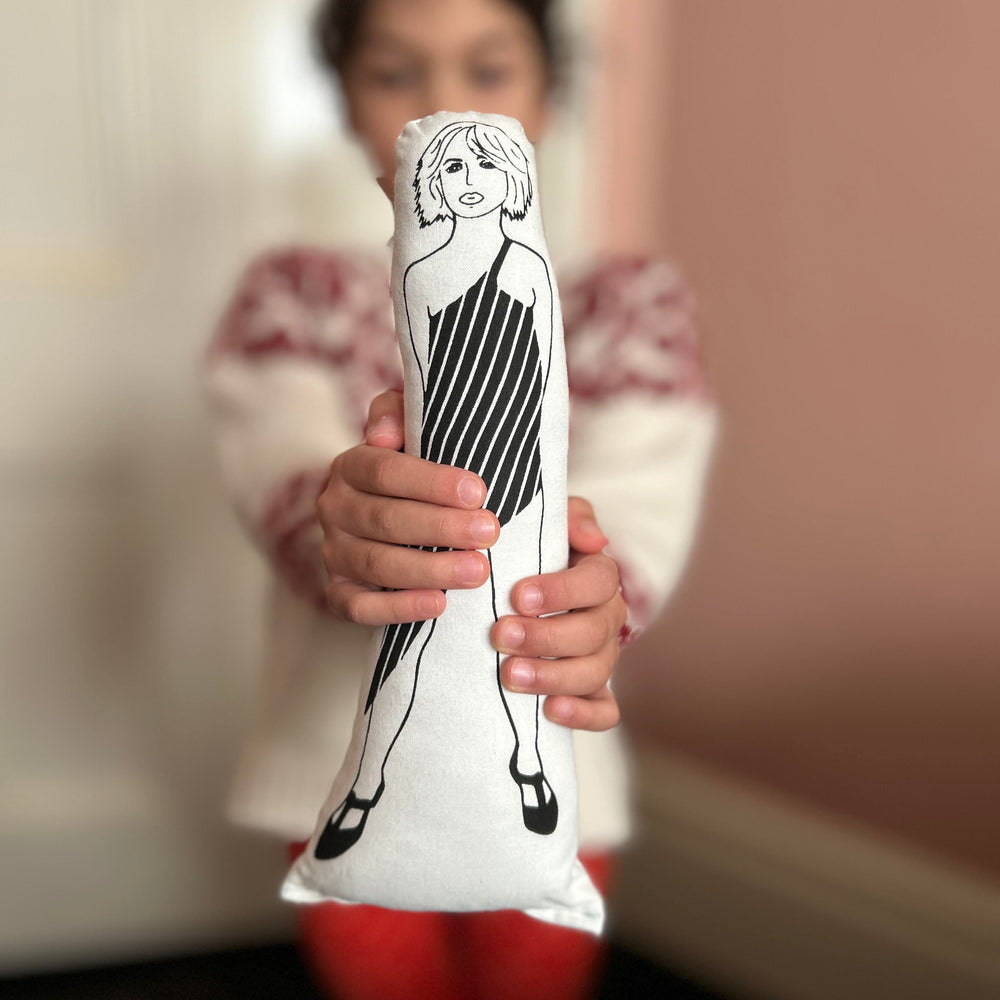 A child holding a black and white screen printed cushion doll depicting Debbie Harry.