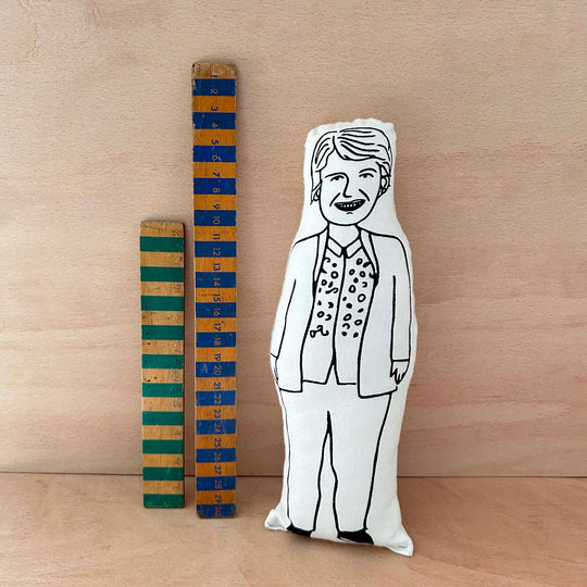 Screen printed doll of Sandi Toksvig next to two wooden colourful rulers