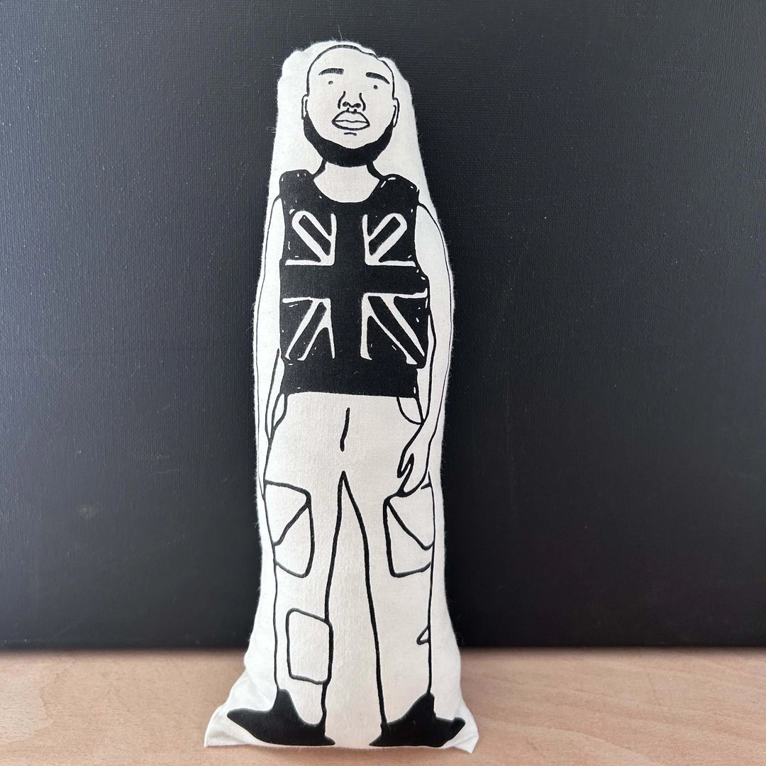 Screen printed black and white doll depicting British rapper Stormzy wearing a Union Jack vest and combat trousers
