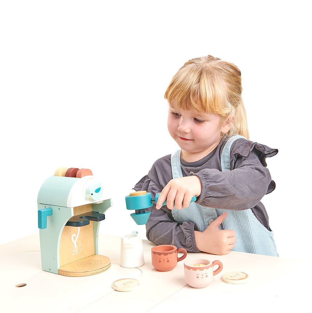 Child playing with a toy tea set on a white background