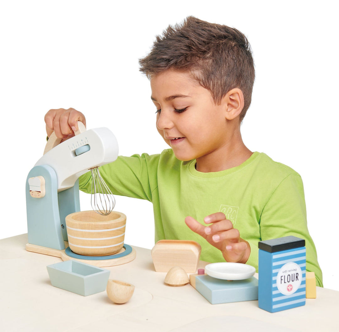 Child playing with a toy mixer set on a white background