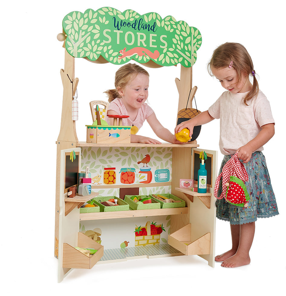 Children playing with a wooden toy store set on a white background