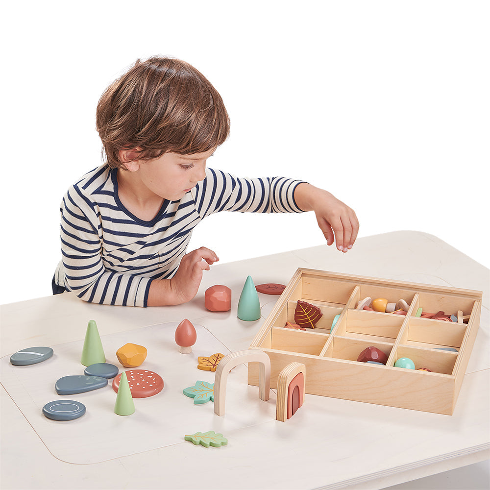 Child playing with wooden toys on a white table