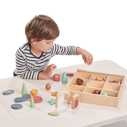 Child playing with wooden toys on a white table