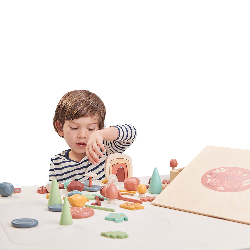 Child playing with wooden toys on a white surface