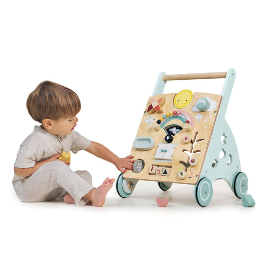 Child playing with a wooden toy push cart on a white background