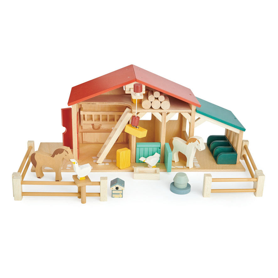 Wooden toy farm set with animals and structures on a white background