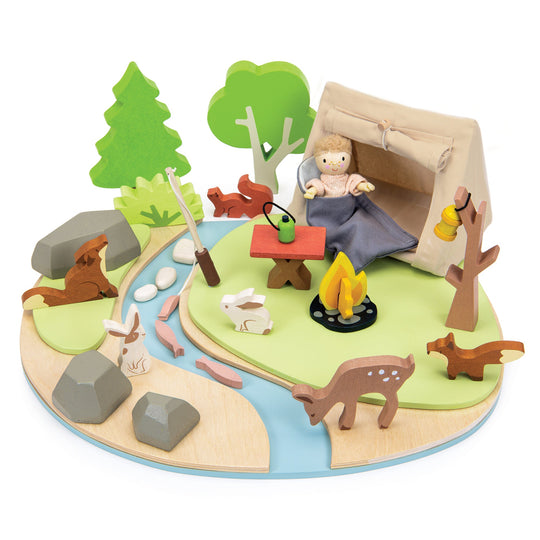 Toy camping scene with a child in a tent, animals, and nature elements on a white background