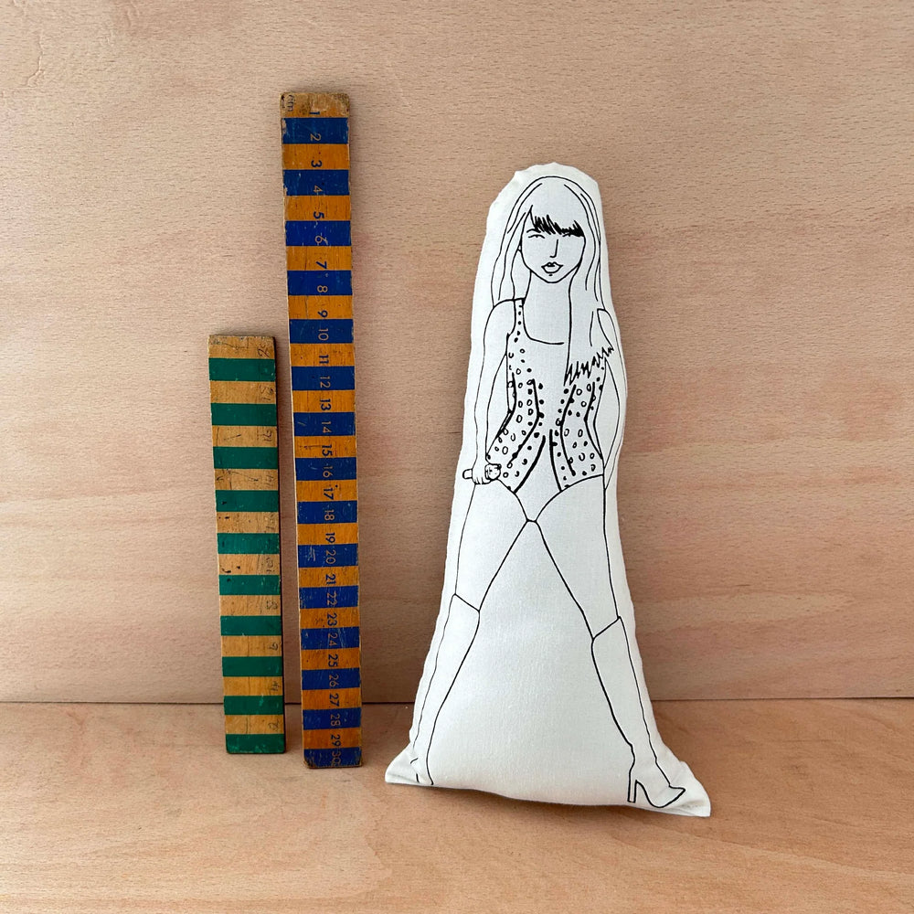 Screen printed Taylor Swift doll next to two wooden rulers