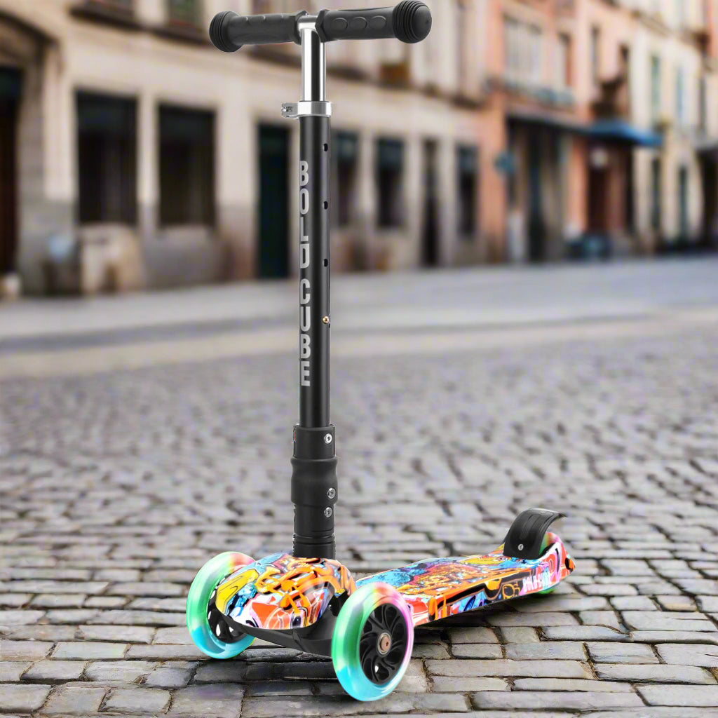 Children's three wheeled scooter with black handles and black vertical bar with 'Bold Cube' written down in, and bright graffiti-style colourful deck with bright flashing wheels