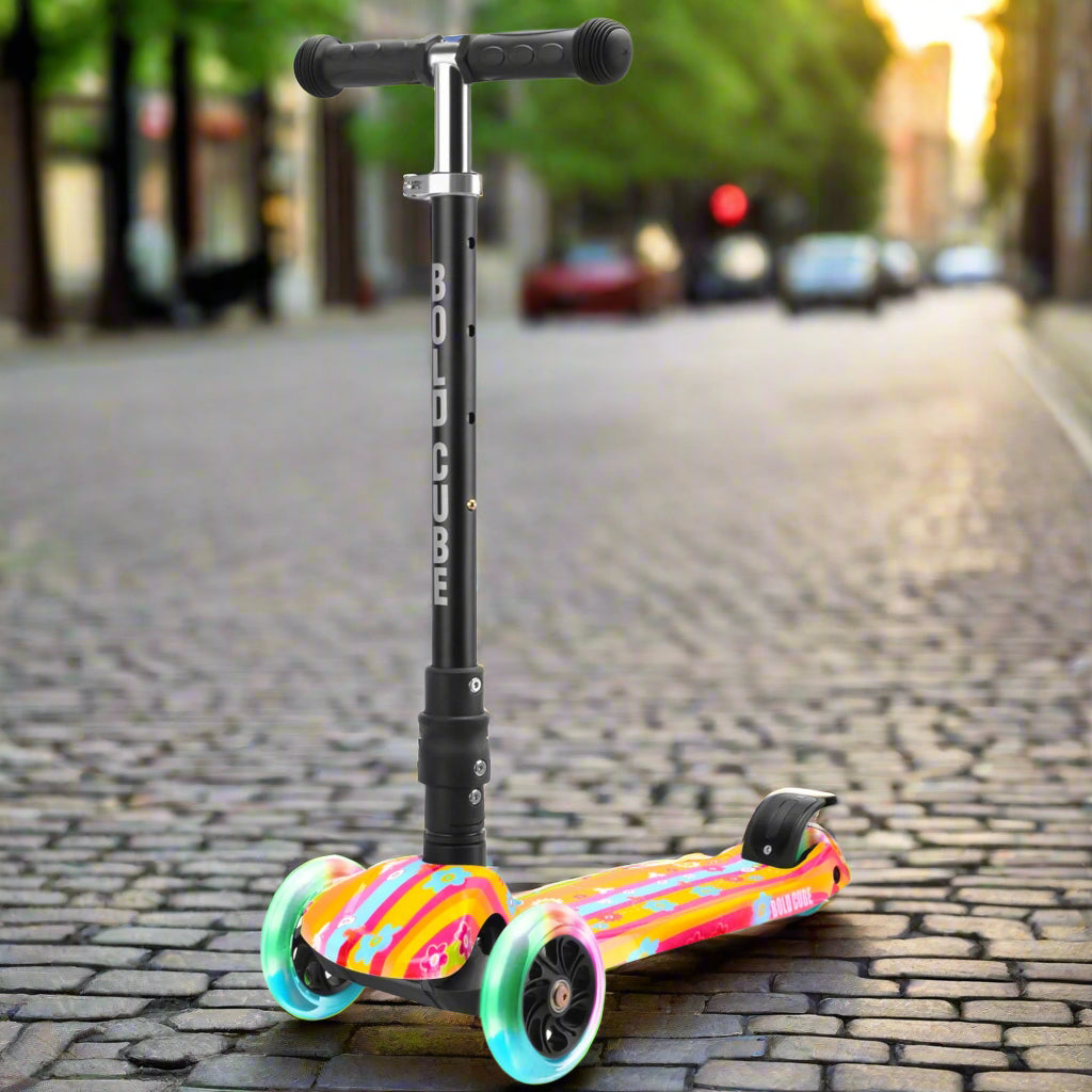 Children's three wheeled scooter with black handles and black vertical bar with 'Bold Cube' written down it and a striped colourful tread with orange, pink and turquoise colours and bright flashing wheels