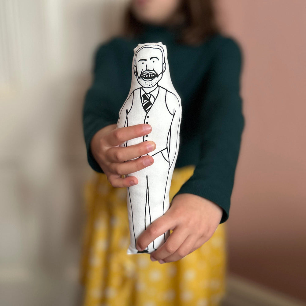 A child holding a black and white screen printed cushion doll depicting Gareth Southgate