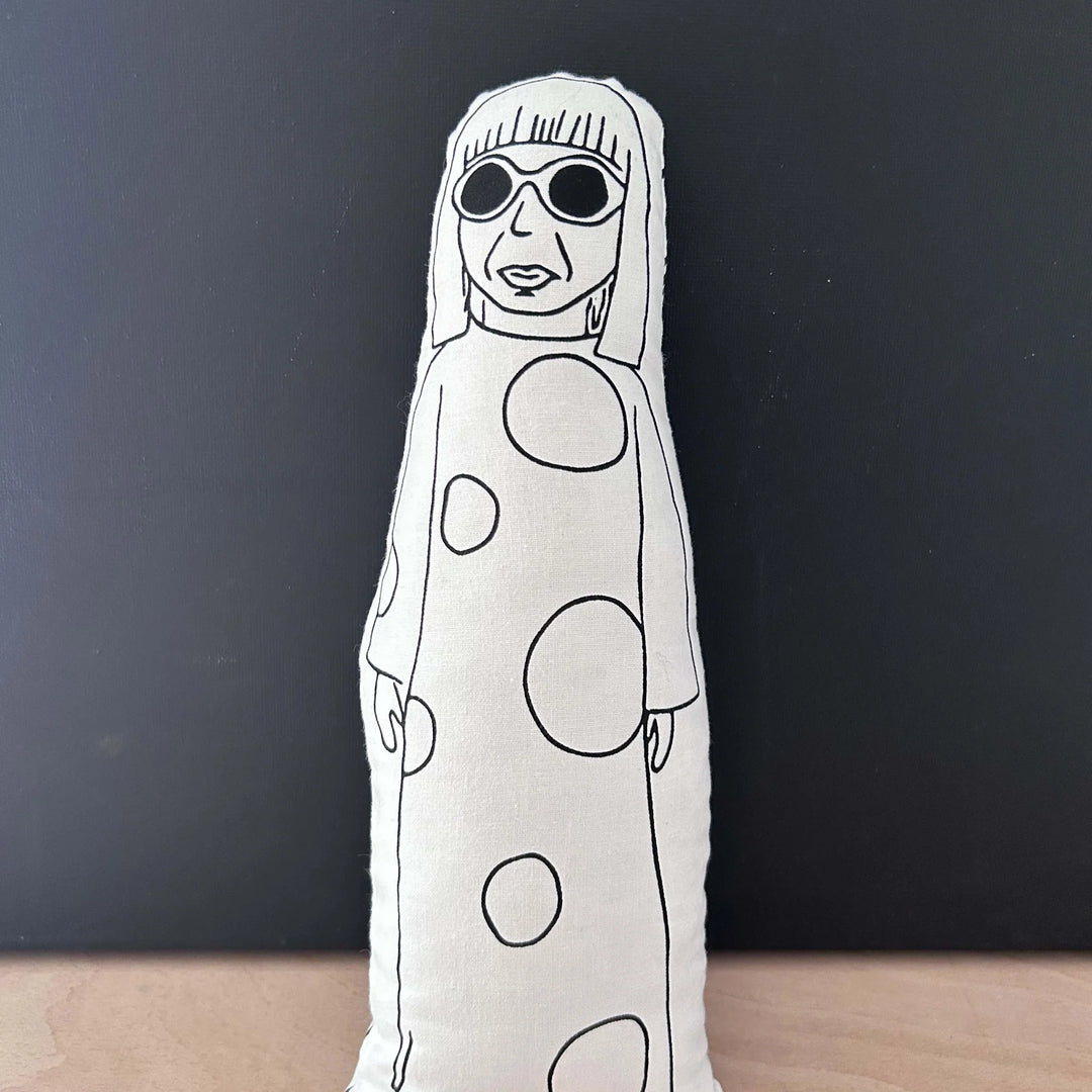 White plush toy with black polka dot pattern on a dark background