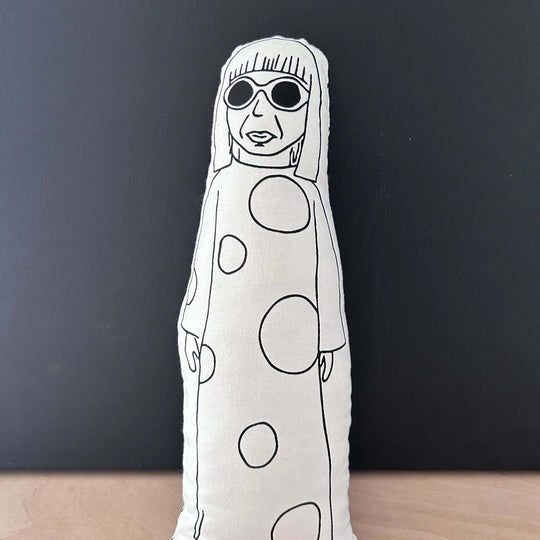 White plush toy with black polka dot pattern on a dark background