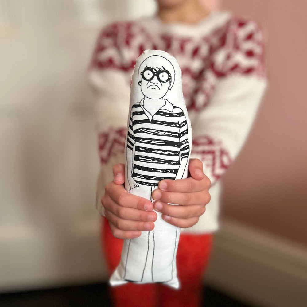 A child holding a screen printed monochrome fabric doll of David Hockney.