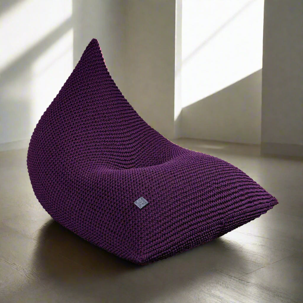 Aubergine purple knitted bean bag chair with a zipper at the bottom, made from chunky cotton cord.
