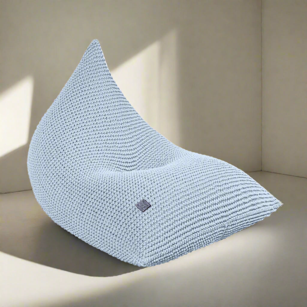 A baby blue handmade knitted bean bag chair with a zipper, made from soft yarn, intended for children's rooms.