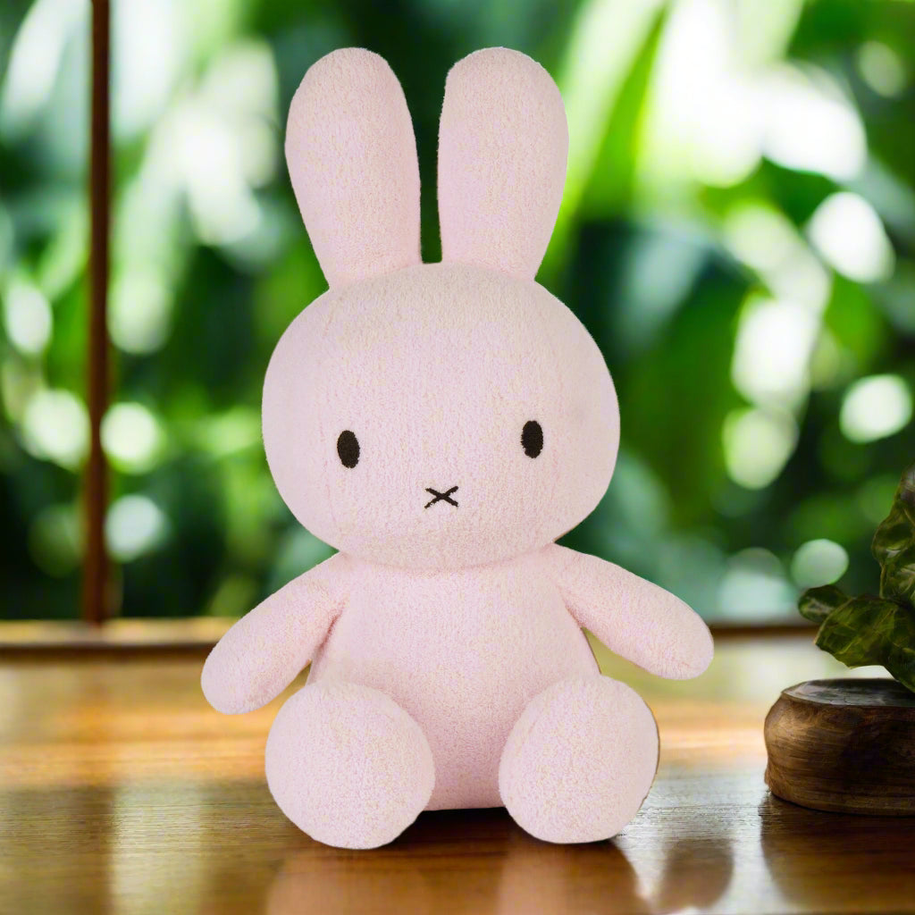 Large pale pink plush stuffed toy rabbit with iconic cross stitched mouth