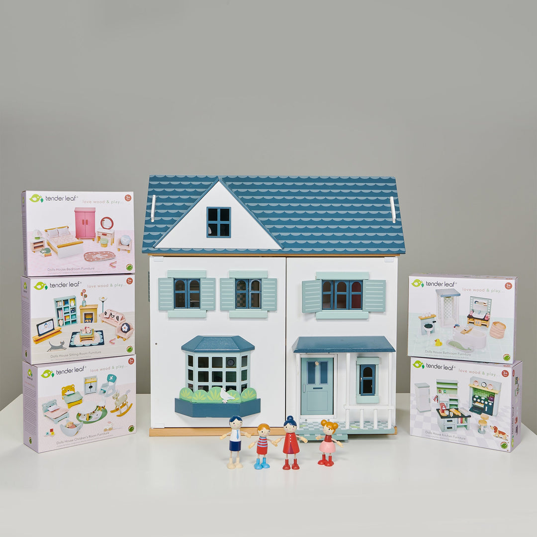 Blue and white dollhouse with accessories and packaging on a grey background