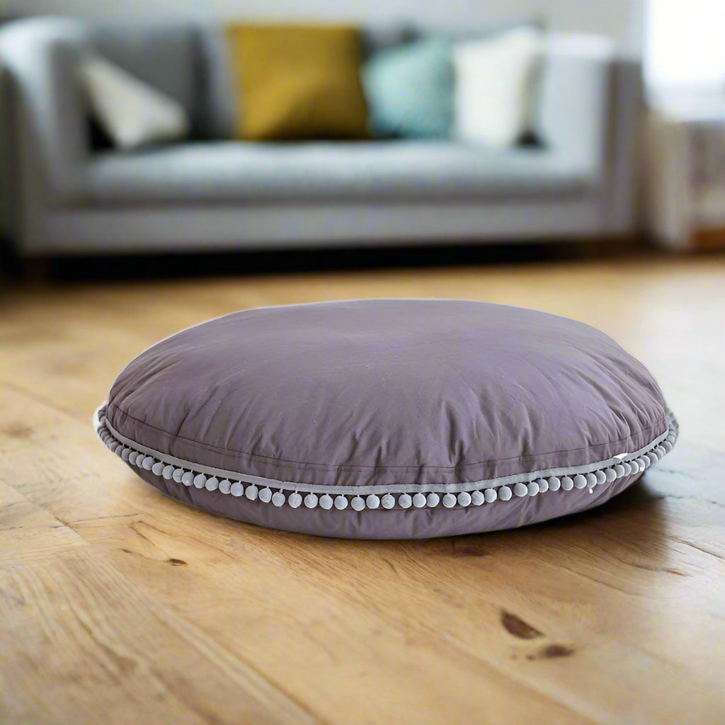 Round grey floor cushion with pom-pom trim