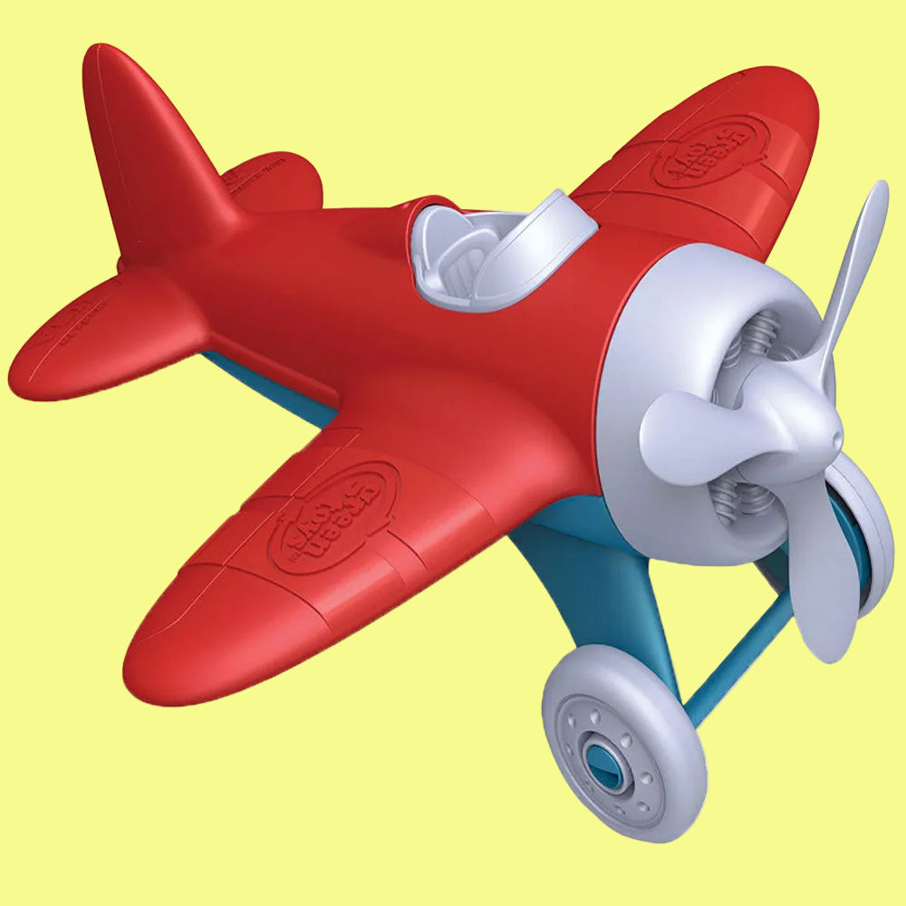 Red toy airplane with a white propeller on a white background
