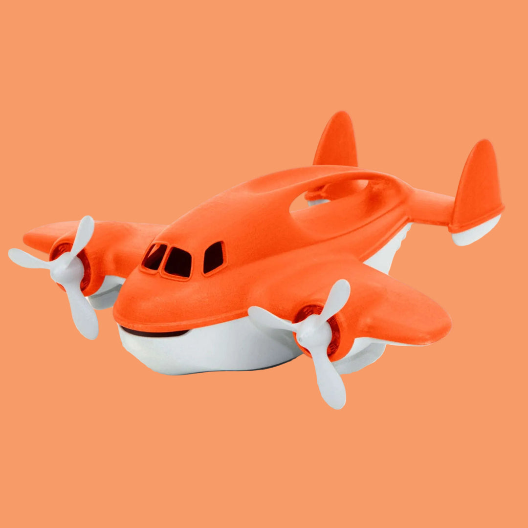 Toy airplane with orange body and white propellers on a white background