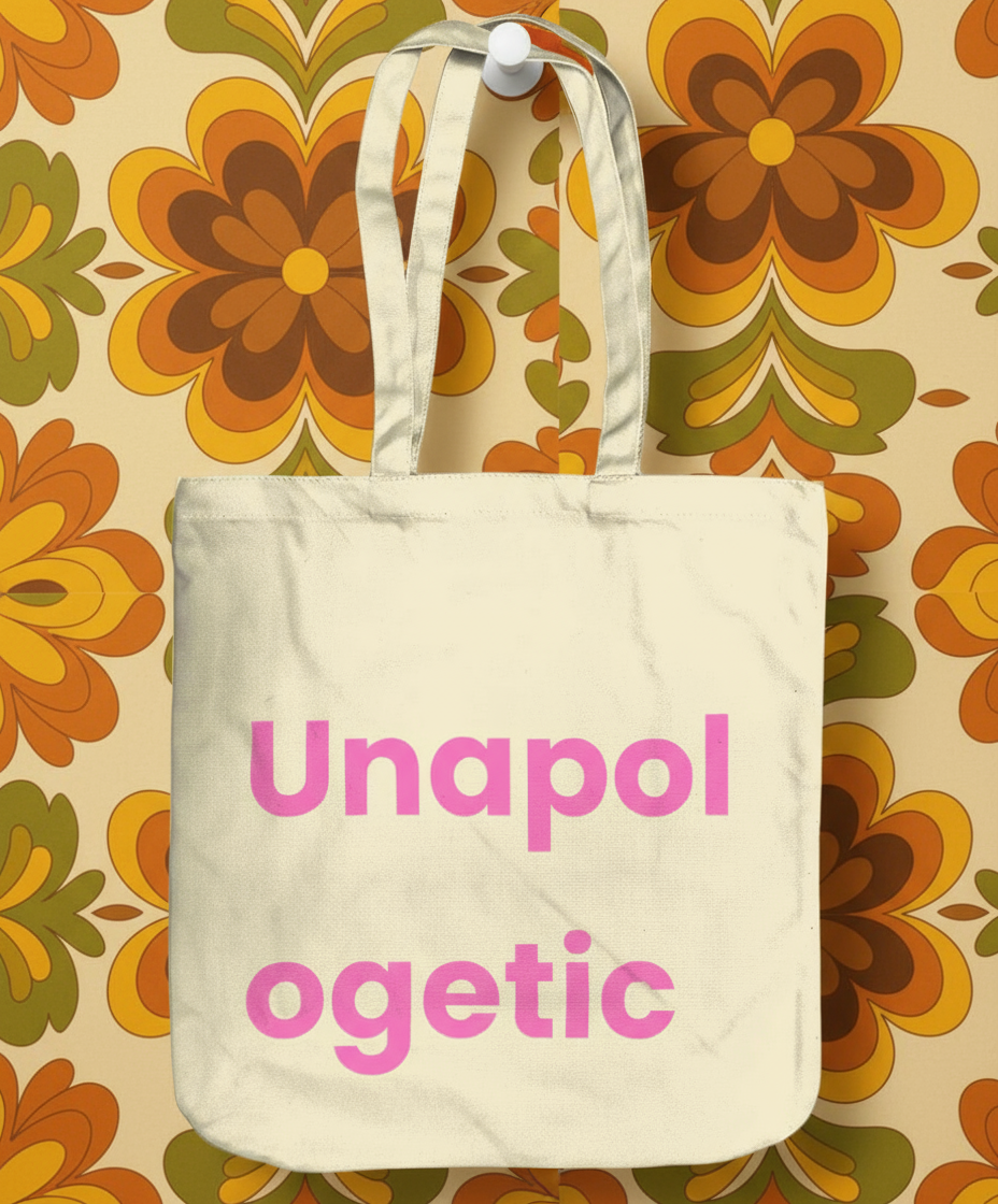 Beige tote bag with pink text 'Unapol ogetic' on a floral background