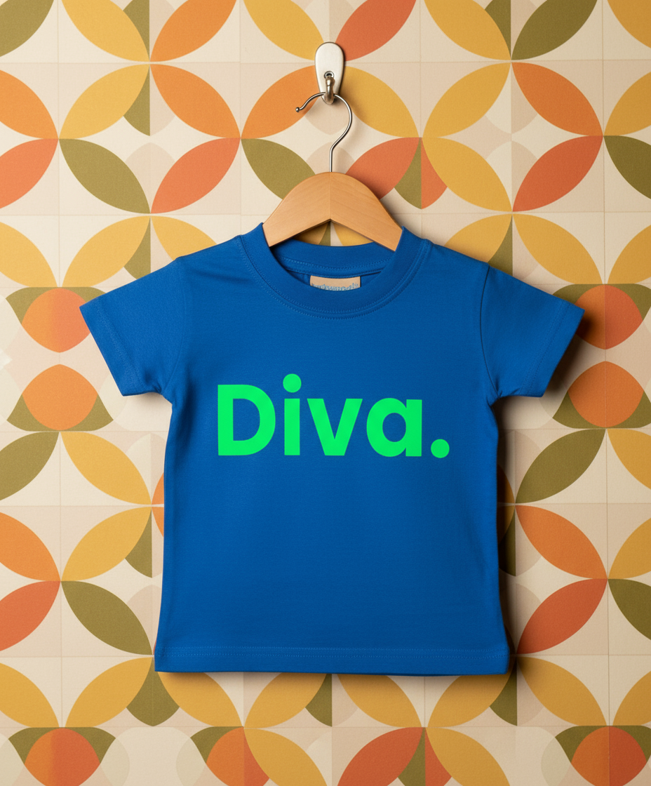 Blue t-shirt with 'Diva.' in green on a hanger against a patterned wall.