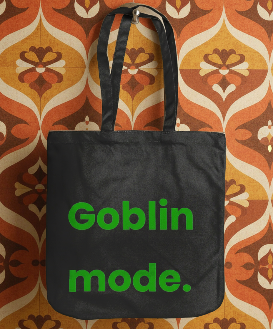 Black tote bag with 'Goblin mode.' text on a patterned background