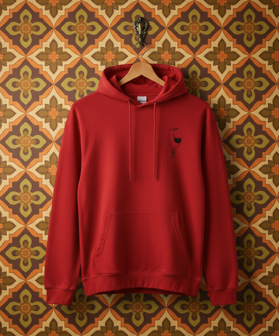 Red hoodie with a small logo on a hanger against a floral wallpaper background