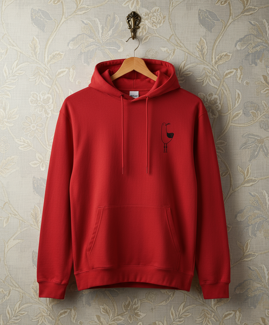 Red hoodie with a small logo on a hanger against a floral wallpaper background