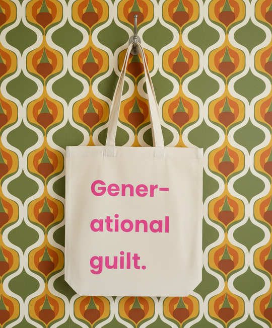 Beige tote bag with 'Generational guilt' text on a patterned wall background