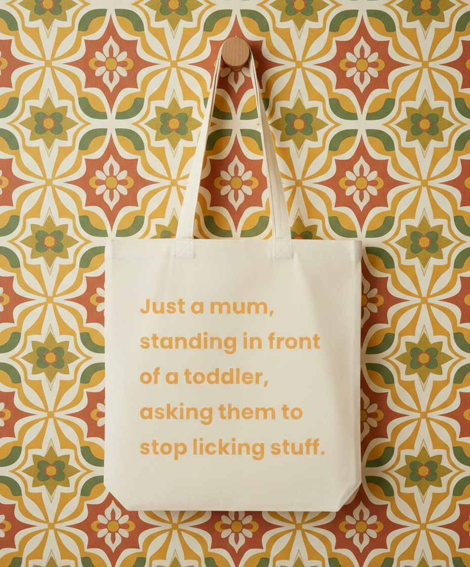 Beige tote bag with humorous text on a patterned background