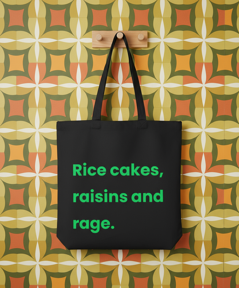 Black tote bag with green text on a patterned wall background